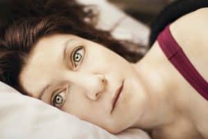 Close up of woman in bed with thoughtful look